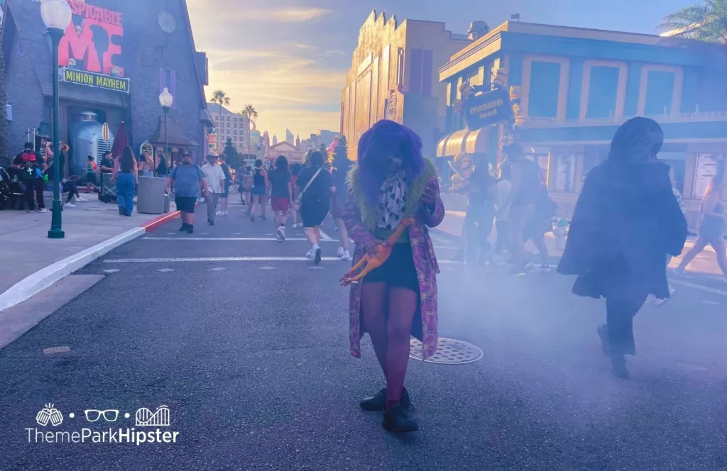 Oddfellow Scare Zone with black woman clown walking through fog during 2023 Halloween Horror Nights HHN 32 at Universal Studios Orlando. Keep reading to learn more about Halloween Horror Nights Stay and Scream.