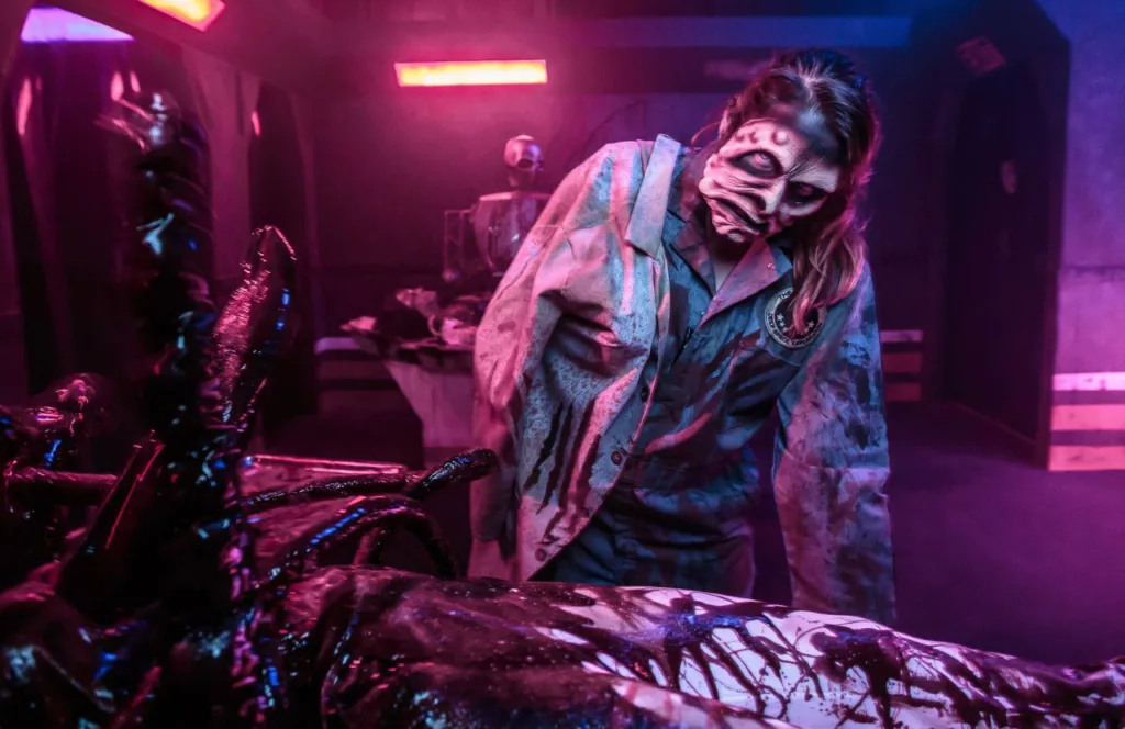 Dark Entities Knott's Berry Farm Maze with space crew alien force member in a bloody scene. Keep reading to learn more about Knott’s Scary Farm mazes. 
