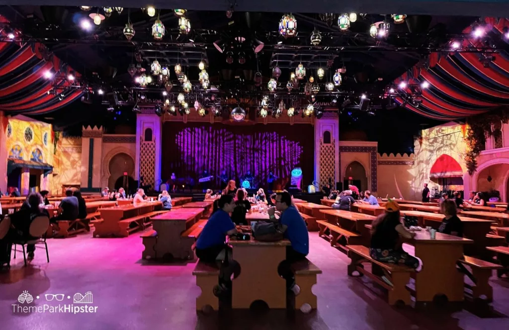 Busch Gardens Tampa Bay Dragon Fire Grill Restaurant during 2023 Howl O Scream with bench style seating and tall ceilings with fabric and lights hanging. Keep reading to learn more about restaurants at Busch Gardens Tampa.