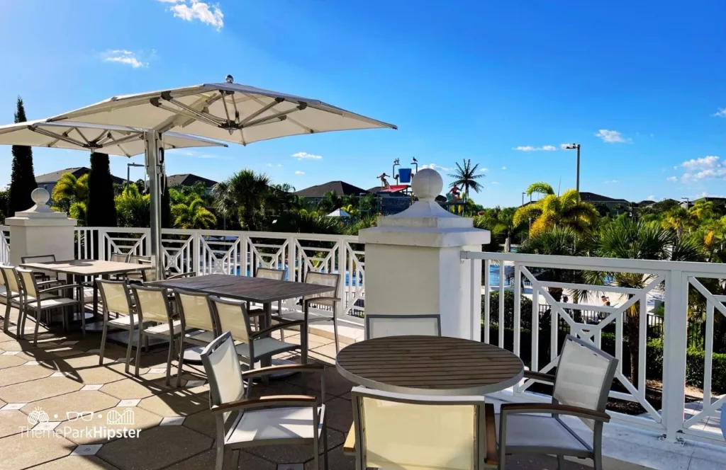 Balcony view of Encore Resort with dining seating and umbrella covered tables. Keep reading to hear more about Encore Resort Orlando. 
