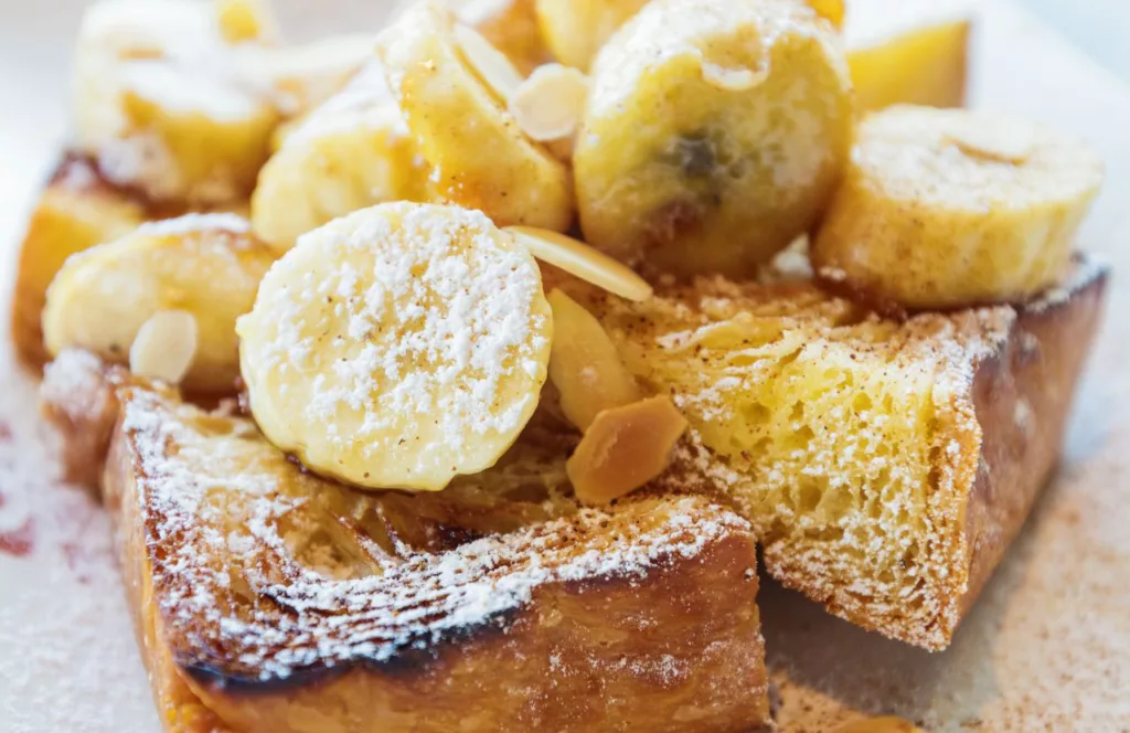 Brioche French Toast topped with powdered sugar. Keep reading to learn more about best things to eat at Disneyland.