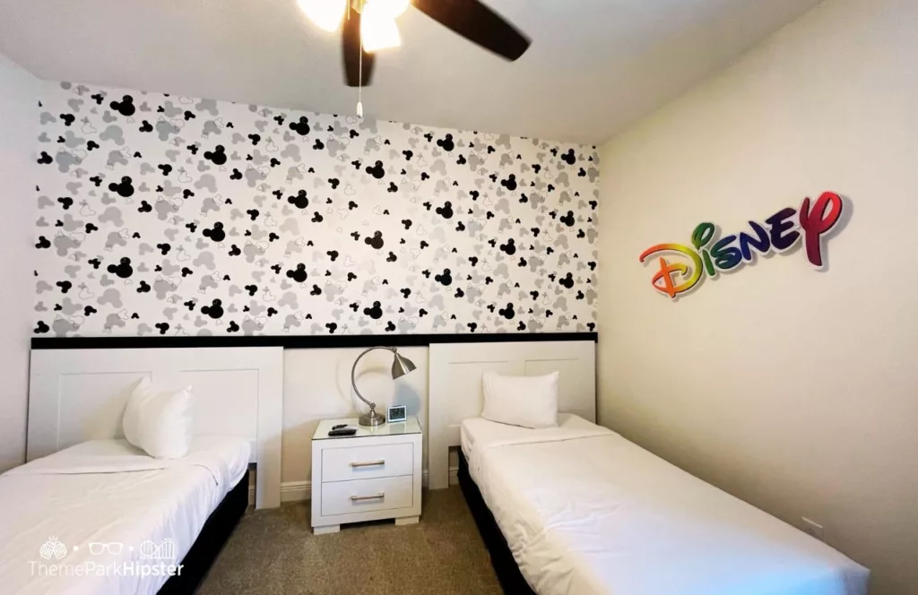 Disney themed room in 5 Bedroom villa at Encore Resort with two beds and Disney black and white wallpaper and Disney on the wall. Keep reading to discover more about Encore Resort. 
