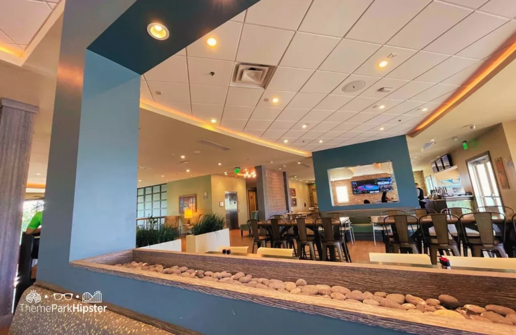 Finn's Restaurant with stone fire center piece and table and chairs with grey color scheme. Keep reading to hear more about Encore Resort.