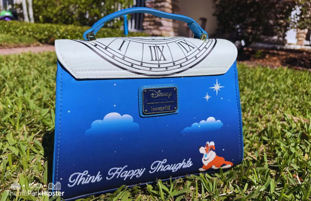 Peter Pan Loungefly Glow in the Dark Crossbody Bag with Think Happy Thoughts and Nana dog on the front. Keep reading to find out the best Disney purses.