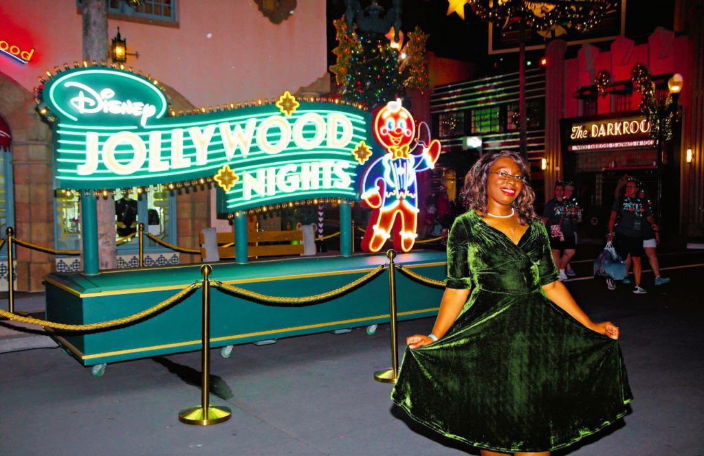 Writer Victoria Wade at Hollywood Studios Jollywood Nights Christmas Celebration at Disney World. Keep reading to see why I love being a solo traveler and traveling to theme parks alone.
