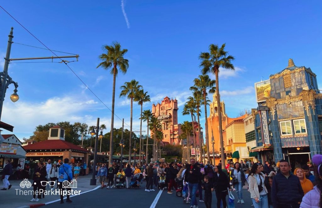 Disney Hollywood Studios Theme Park sunset boulevard with tower of terror. Keep reading to see why you must go to Hollywood Studios alone on your solo Disney trip.