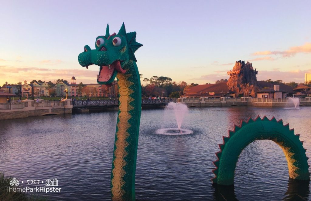 Walt Disney World Disney Springs Lego Dragon in Lagoon with Rainforest Cafe in Background and Saratoga Springs. Keep reading for the full guide to parking at Disney Springs.